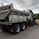 Épandeur avec cylindre dompeur et porte arrière