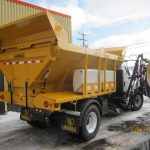 Épandeur avec cylindre dompeur et porte arrière