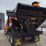 Épandeur avec cylindre dompeur et porte arrière